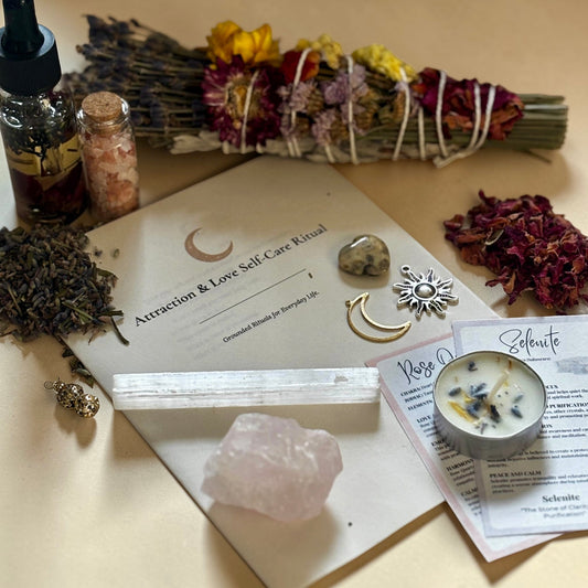 Goddess self-care ritual items including crystals, herbs, and a candle on a wooden surface.